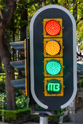 A closeup shot of a traffic light with all the coloured lights on
