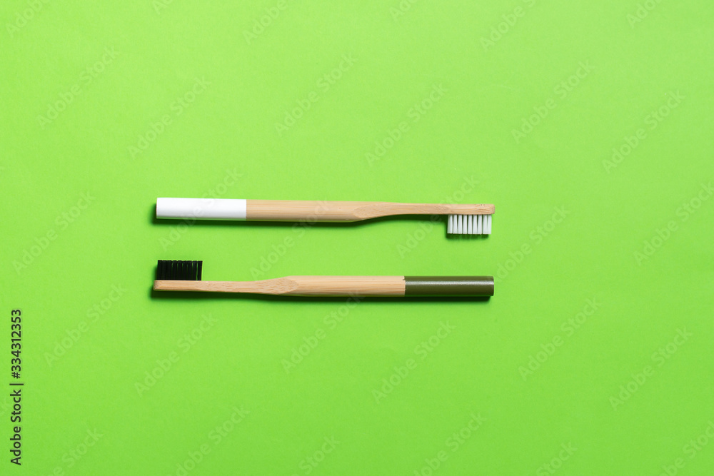 white and dark green bamboo toothbrushes on a green background. eco friendly. isolate white and dark green bamboo toothbrushes on a green background. eco friendly. isolate