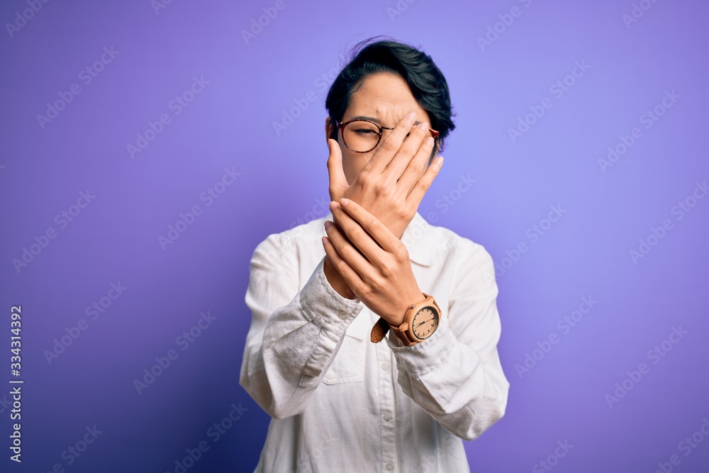 Young beautiful asian girl wearing casual shirt and glasses standing over purple background Suffering pain on hands and fingers, arthritis inflammation Young beautiful asian girl wearing casual shirt and glasses standing over purple background Suffering pain on hands and fingers, arthritis inflammation
