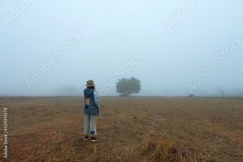 dramatic foggy field with a woman. 