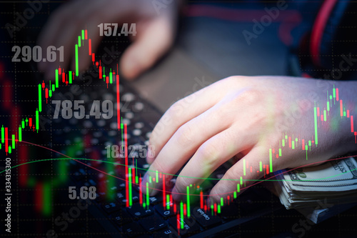 Hands, keyboard and money close-up on the background of stock quotes. The concept of exchange trading. The game is based on changing exchange rates. Securities market. Forex.