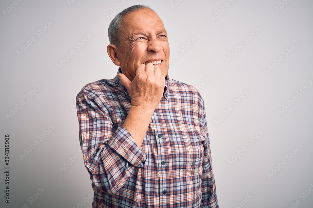 Senior handsome man  wearing casual shirt standing over isolated white background looking stressed and nervous with hands on mouth biting nails. Anxiety problem.
