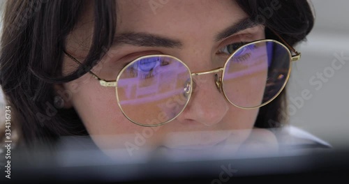 Cute 20s lady working at desk in trendy hipster start up office using shared data. Pretty face close up with emotion of joy and happy success. Student writing a report on successful marketing