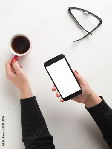 Business morning with mobile, cup of coffee, glasses, white background Top view mockup smartphone white screen