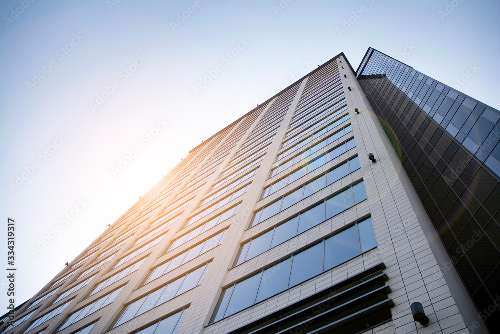 Skyscraper, modern building in the city with sunlight. Glass wall of an office building in the sunlight. Office building window close up with sunrise, reflection and perspective. Skyscraper, modern building in the city with sunlight. Glass wall of an office building in the sunlight. Office building window close up with sunrise, reflection and perspective.
