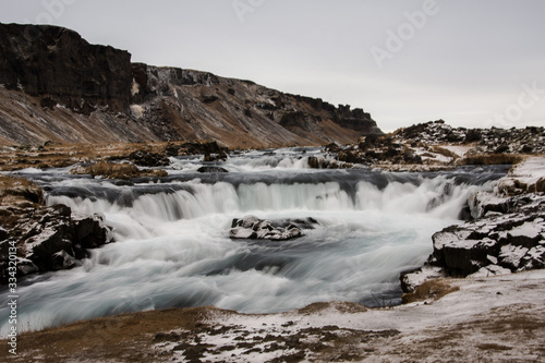 River stream in Iceland nature in wintertime during a cloudy day. Explore barely populated Viking`s land. Iceland, Europe.
