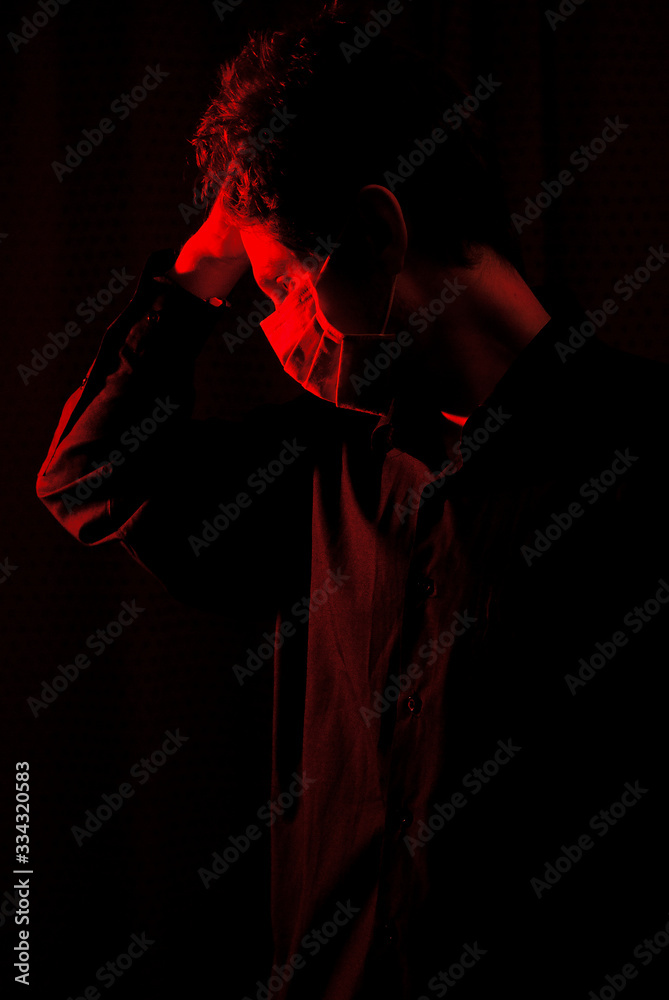 Obraz premium masked doctor in a dark room with red light