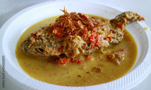 Pecak mujair or Mozambique tilapia on white background. Spicy Indonesian cuisine. photo
