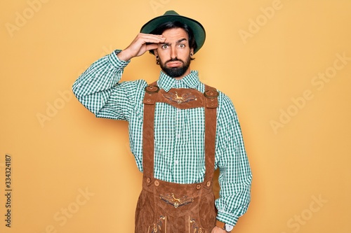 Young handsome man wearing tratidional german octoberfest custome for Germany festival worried and stressed about a problem with hand on forehead, nervous and anxious for crisis