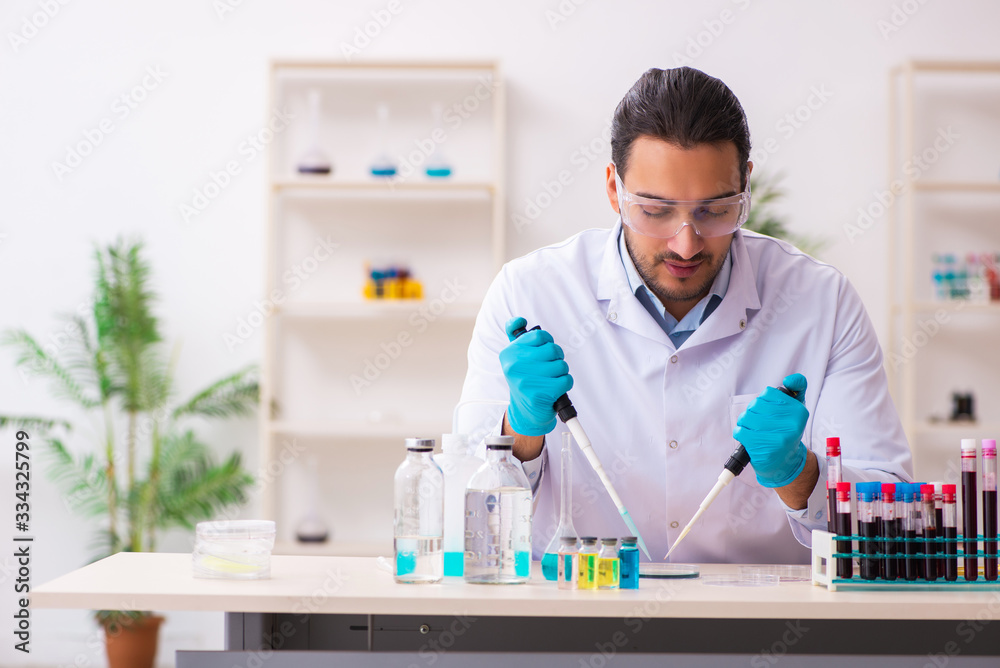 Young male chemist working in the lab Young male chemist working in the lab