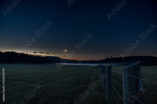 Nightscape astrophotography in a foggy field near farm