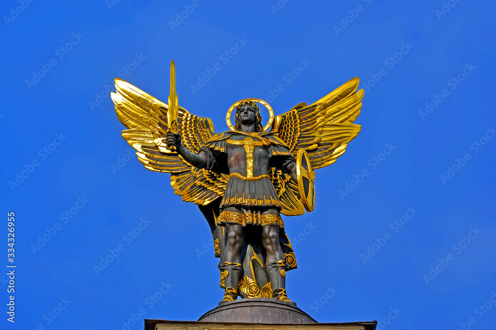 Golden statue of St. Michael with sword on blue sky on February 18 ...