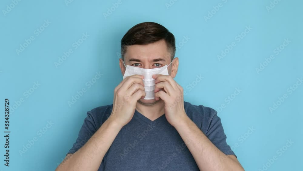 Man putting on protective face mask for coronavirus or covid-19 prevention Man putting on protective face mask for coronavirus or covid-19 prevention