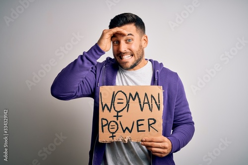 Young handsome activist man protesting for woman power holding cardboard banner stressed with hand on head, shocked with shame and surprise face, angry and frustrated. Fear and upset for mistake.