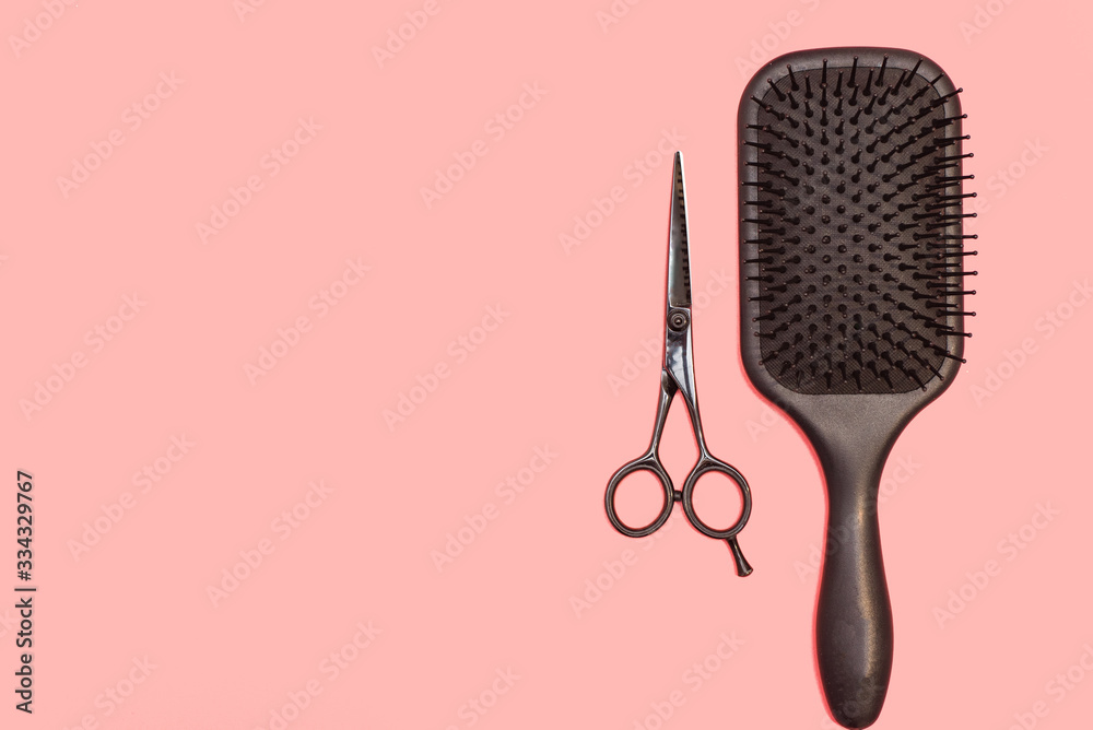 Professional black comb and scissors. Hairdresser tools on a pink pastel background. Flat lay, copyspace - obrazy, fototapety, plakaty 