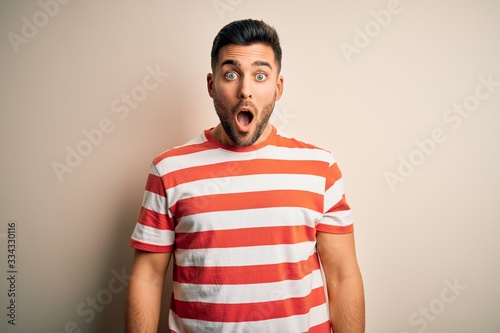 Wallpaper Mural Young handsome man wearing casual striped t-shirt standing over isolated white background afraid and shocked with surprise and amazed expression, fear and excited face. Torontodigital.ca