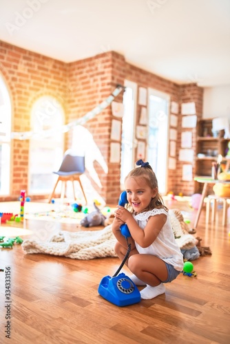 Young beautiful blonde girl kid enjoying play school with toys at kindergarten, smiling happy playing at home