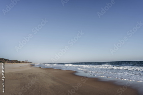 Atlantic Ocean beach with strong waves. Long Island New York shore. Blue sky with blue ocean. 