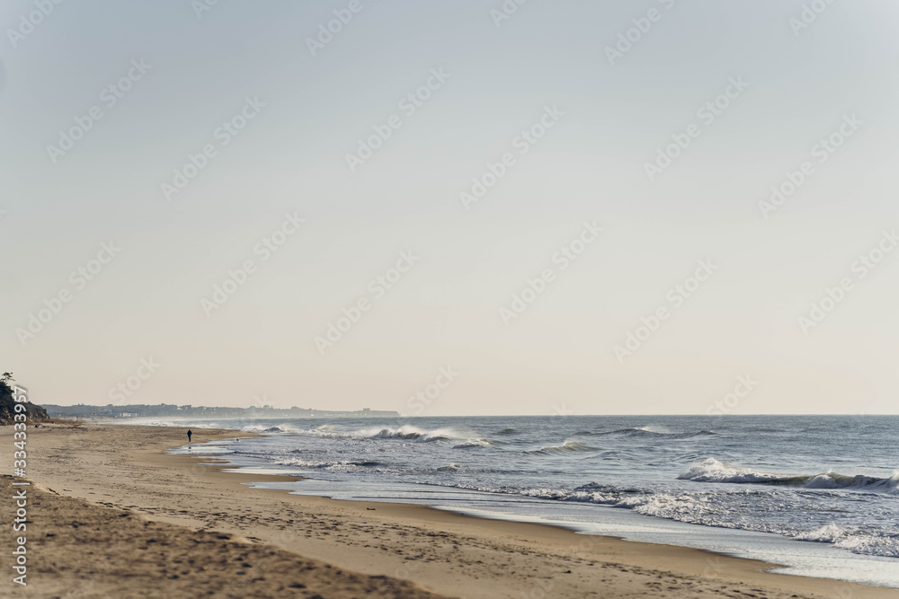 Atlantic Ocean beach with strong waves. Long Island New York shore. Blue sky with blue ocean. 