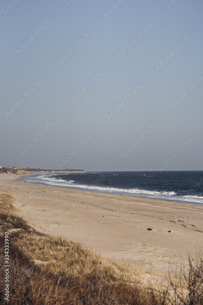 Atlantic Ocean beach with strong waves. Long Island New York shore. Blue sky with blue ocean. 