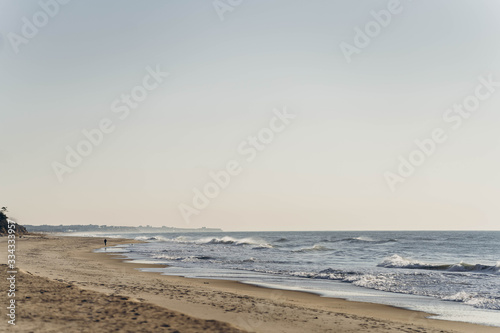 Atlantic Ocean beach with strong waves. Long Island New York shore. Blue sky with blue ocean. 