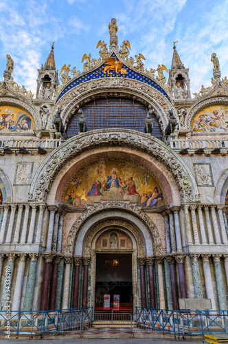 Saint Mark's Basilica facade with main portal mosaic of Christ and Last Judgment and a winged lion in Venice, Italy