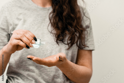 Close up view of woman person using small portable antibacterial hand sanitizer on hands. Woman with antibacterial antiseptic gel for hands disinfection and health protection prevention during flu  photo