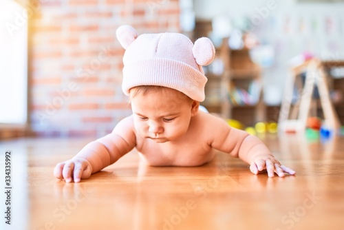 Adorable baby lying down on the sofa at home. Newborn wearing fanny hat relaxing and resting comfortable © Krakenimages.com