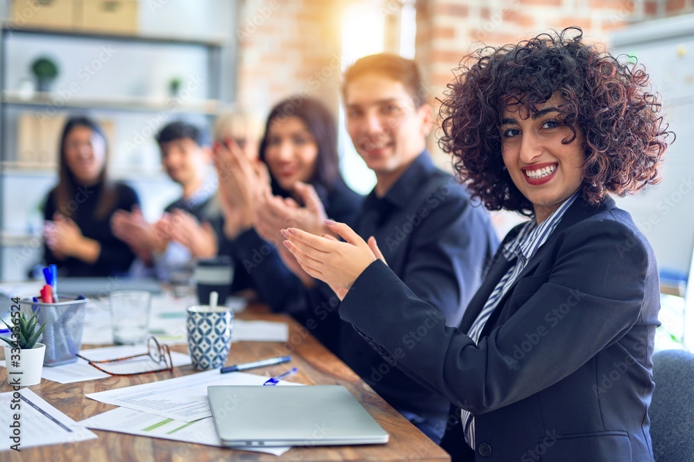 Group of business workers smiling happy and confident. Working together with smile on face looking at the camera applauding at the office Group of business workers smiling happy and confident. Working together with smile on face looking at the camera applauding at the office