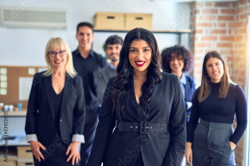 Group of business workers smiling happy and confident. Posing together looking at the camera, young beautiful woman with smile on face at the office