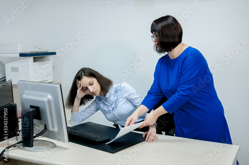Fotografija The boss shows the document to the brunette in the office, the girl is tired