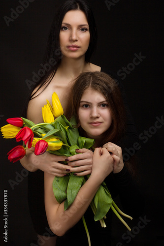 Portrait of girl and woman with tulips in the Studio