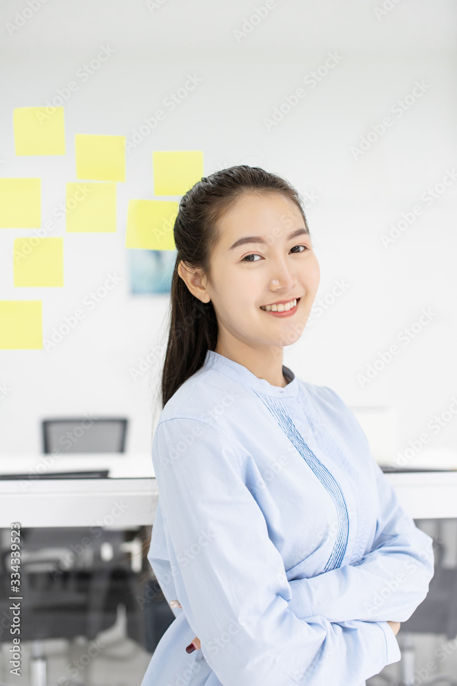 Attractive Asian young businesswoman write lecture short note to do list in sticker on glass in meeting office room Attractive Asian young businesswoman write lecture short note to do list in sticker on glass in meeting office room