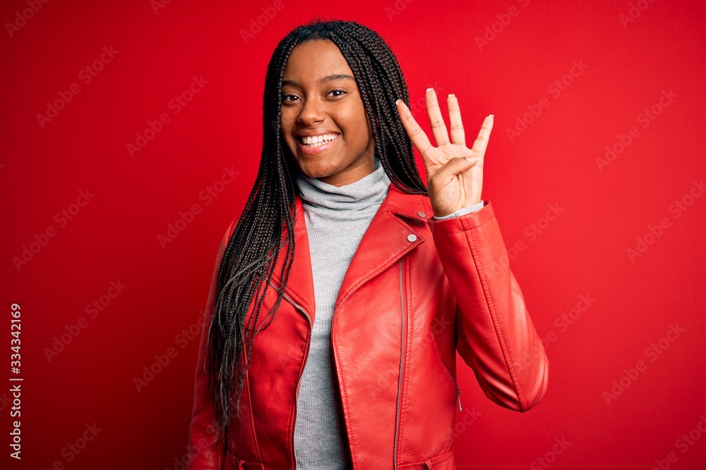 Young african american woman wearing cool fashion leather jacket over red isolated background showing and pointing up with fingers number four while smiling confident and happy. Young african american woman wearing cool fashion leather jacket over red isolated background showing and pointing up with fingers number four while smiling confident and happy.