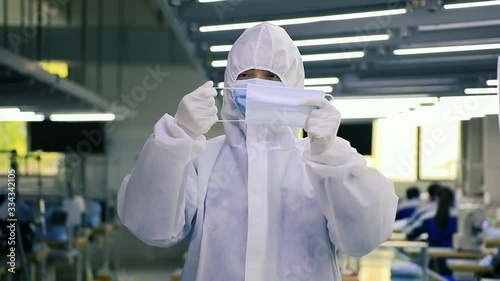 Workers in Protective clothing check the quality of surgical masks as the global outbreak of COVID 19 severely undersupplies Personal Protective Equipment in hospitals. photo