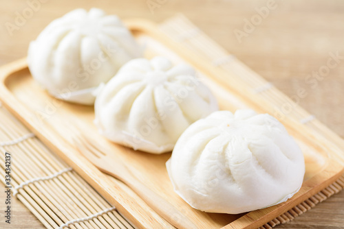 Steamed buns stuffed with minced pork on wooden plate and fork ready to eating, Asian food