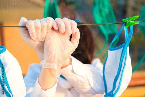 Young girl assistant cleaning masks in these days of pandemic. Also tired and sad.