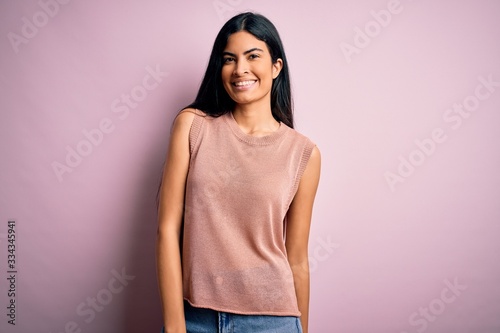 Young beautiful woman wearing fashion urban clothes, model wearing casual street style standing over pink background