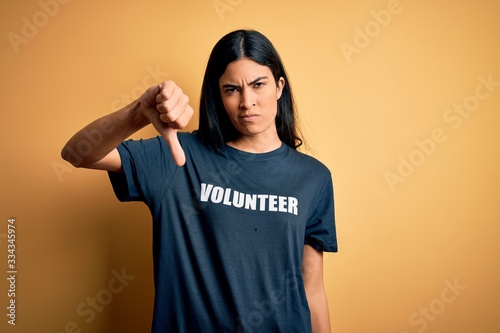 Young beautiful hispanic woman wearing volunteer t-shirt as social charity moral looking unhappy and angry showing rejection and negative with thumbs down gesture. Bad expression. © Krakenimages.com