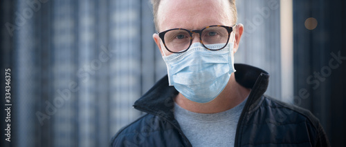Mature man with mask for protection from corona virus outbreak and pollution in the city