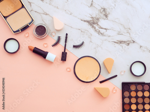 Makeup tools, cosmetics on two colored background on pink and marble