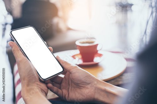 cell phone Mockup image blank white screen.woman hand holding texting using mobile on desk at coffee shop.background empty space for advertise text.people contact marketing business,technology