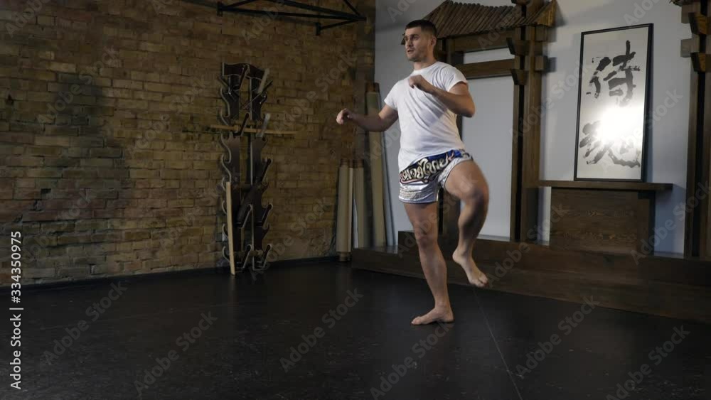 Martial Arts Fighter Performing Legs Workout. Sportsman Training Preparing For Fight. Limbering-up. Professional Sportsman Preparing for Competition. Athlete Intensive Training in Eastern Asia Style S Martial Arts Fighter Performing Legs Workout. Sportsman Training Preparing For Fight. Limbering-up. Professional Sportsman Preparing for Competition. Athlete Intensive Training in Eastern Asia Style S