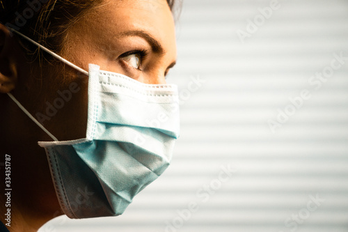 Sideview profile of young female wearing surgical mask
