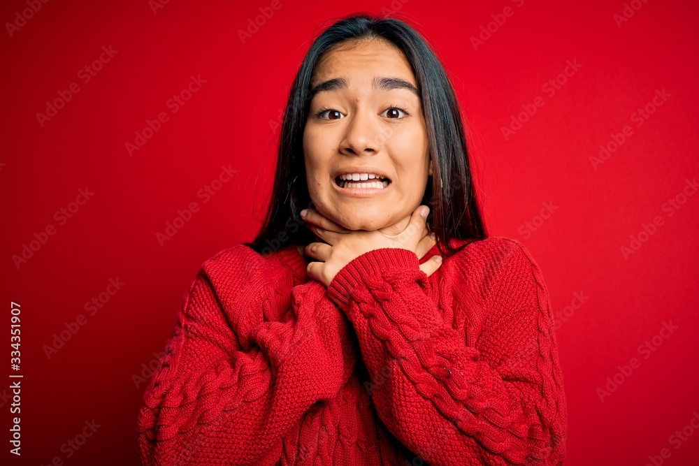 Young beautiful asian woman wearing casual sweater standing over isolated red background shouting and suffocate because painful strangle. Health problem. Asphyxiate and suicide concept. Young beautiful asian woman wearing casual sweater standing over isolated red background shouting and suffocate because painful strangle. Health problem. Asphyxiate and suicide concept.