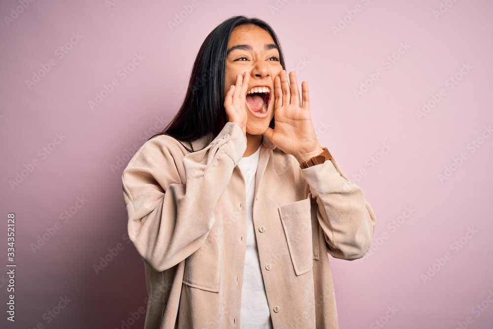 Young beautiful asian woman wearing casual shirt standing over pink background Shouting angry out loud with hands over mouth Young beautiful asian woman wearing casual shirt standing over pink background Shouting angry out loud with hands over mouth