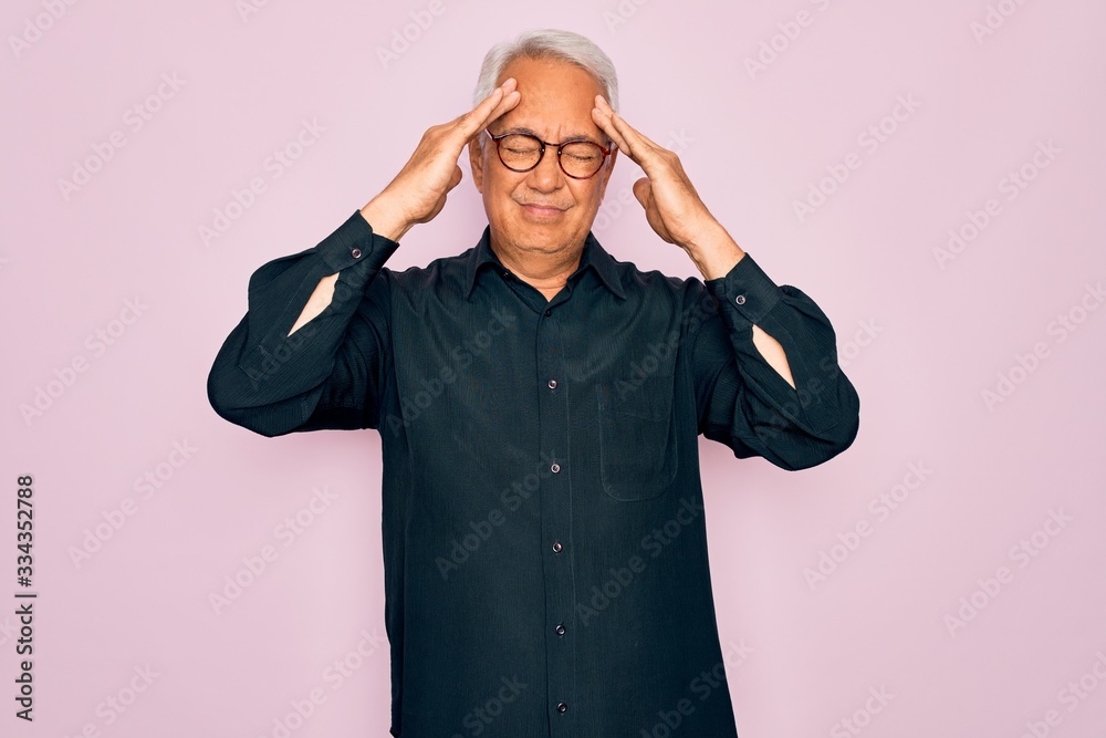 Middle age senior grey-haired handsome man wearing glasses and elegant shirt suffering from headache desperate and stressed because pain and migraine. Hands on head. Middle age senior grey-haired handsome man wearing glasses and elegant shirt suffering from headache desperate and stressed because pain and migraine. Hands on head.