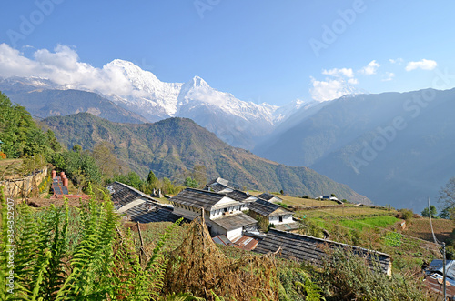 View at Ghandruk village, its buildings and grey roofs with Annapurna massif at the background with Fishtail mountain. The Himalayas mountains, Nepal. photo