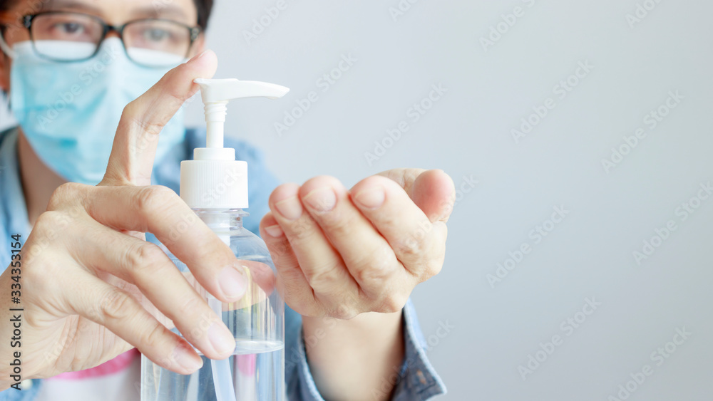 a man wearing medical protective mask and using sanitizer gel on his hands as prevention measures against coronavirus COVID-19 a man wearing medical protective mask and using sanitizer gel on his hands as prevention measures against coronavirus COVID-19