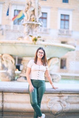 Young beautiful woman smiling happy and confident. Standing with smile on face at the town street